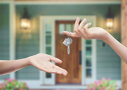 Two people, One of them handing a key to the other.